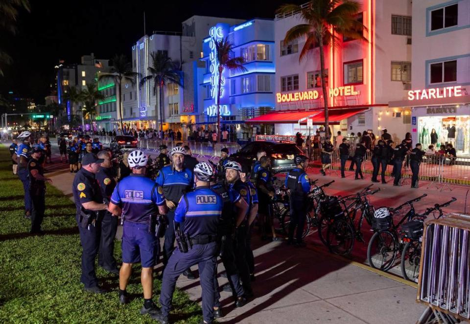 Police officers gather on Ocean Drive before the start of a midnight curfew during spring break on Friday, March 15, 2024, in Miami Beach.