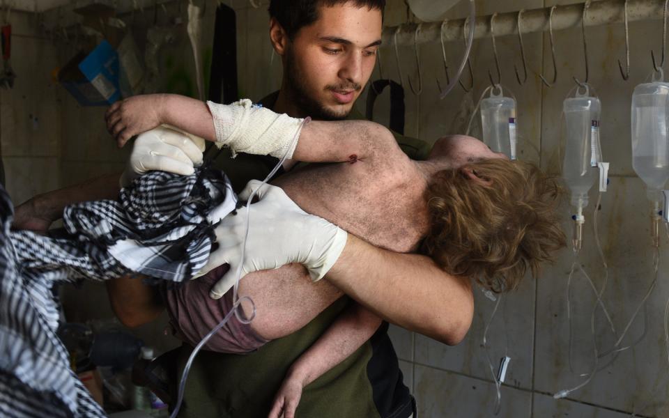 Amina is pulled from the rubble by Iraqi rescue workers - Credit: Carol Guzy/Rex