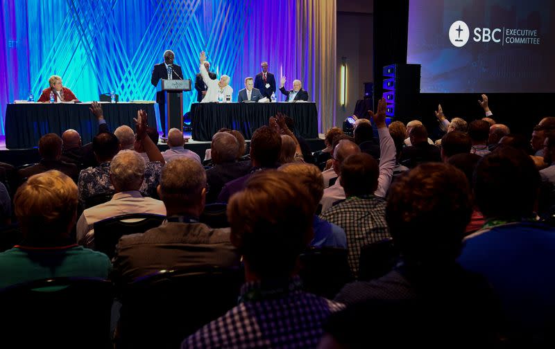 Members of the Southern Baptist Convention executive committee vote on a motion during their meeting at Music City Center in Nashville