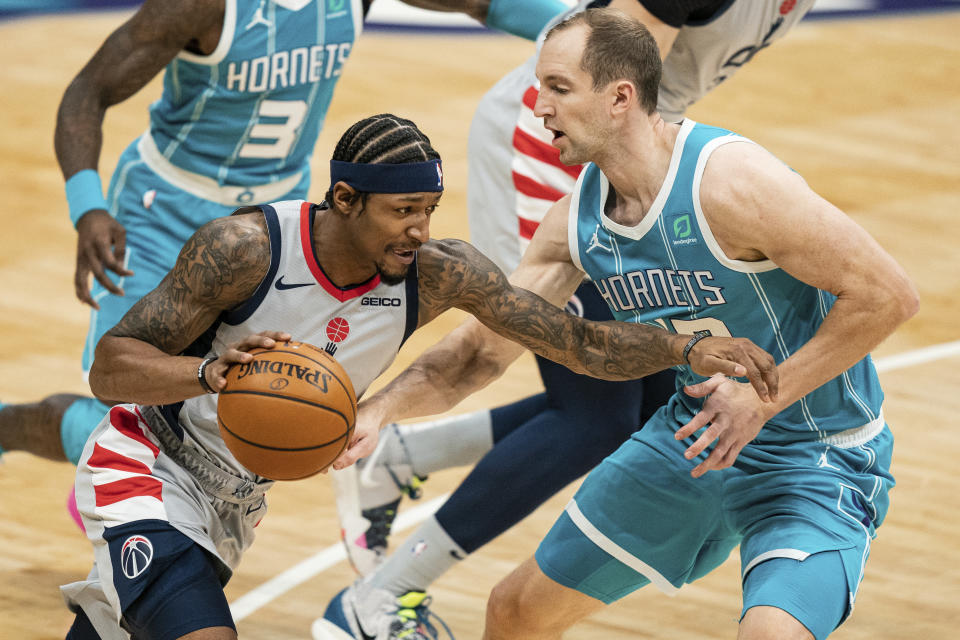 Washington Wizards guard Bradley Beal, front left, drives to the basket while guarded by Charlotte Hornets center Cody Zeller, right, during the first half of an NBA basketball game in Charlotte, N.C., Sunday, Feb. 7, 2021. (AP Photo/Jacob Kupferman)