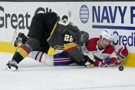Vegas Golden Knights defenseman Nick Holden (22) and Montreal Canadiens center Jesperi Kotkaniemi (15) battle against the boards during the third period in Game 5 of an NHL hockey Stanley Cup semifinal playoff series Tuesday, June 22, 2021, in Las Vegas. (AP Photo/John Locher)