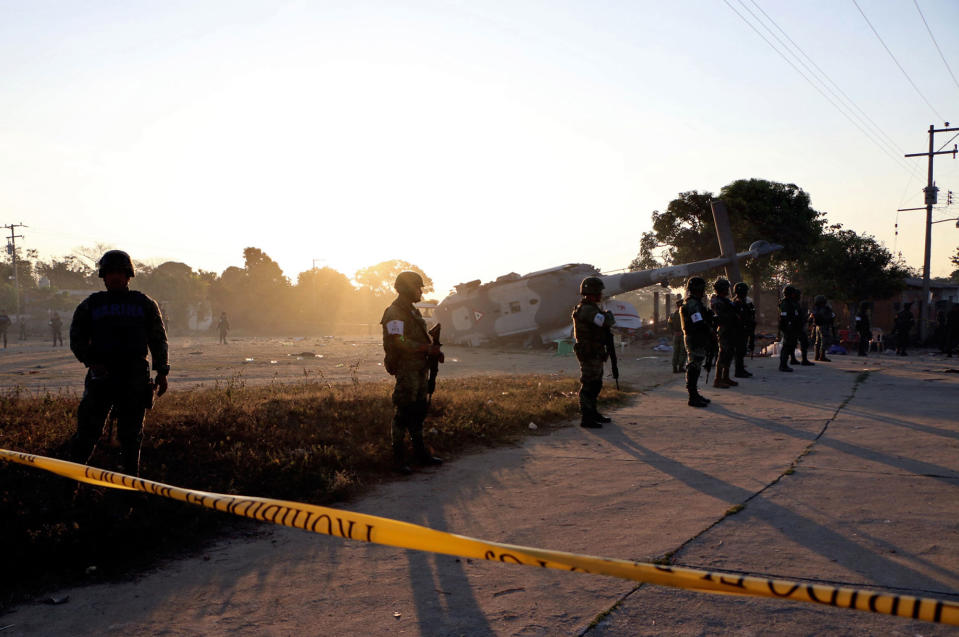 <p>Soldiers stand guard next to the remains of the military helicopter that on a van fell in Santiago Jamiltepec, Oaxaca state, Mexico, on Feb.17, 2018. (Photo: Patricia Castellanos/AFP/Getty Images) </p>