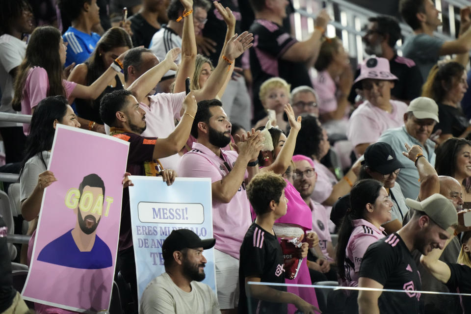 Fans cheer and hold up signs for Inter Miami forward Lionel Messi during the second half of an MLS soccer match between Inter Miami and Toronto FC, Wednesday, Sept. 20, 2023, in Fort Lauderdale, Fla. Inter Miami's attendance is up 36% over last year. (AP Photo/Wilfredo Lee)