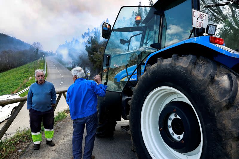 Local farmer Andres Perez, 68, observes a blaze near the village of Setienes during an outbreak of wildfires in northern Spain's Asturias region