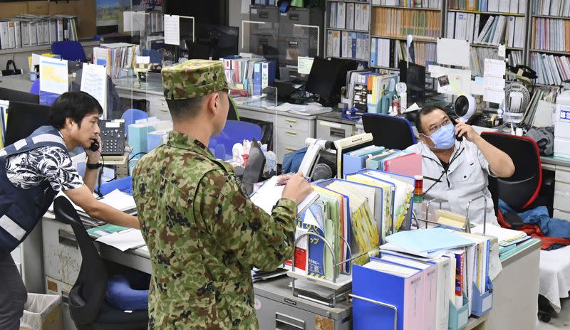 Prefectural office staff members react after possible threat of a North Korean missile in Naha, Okinawa prefecture