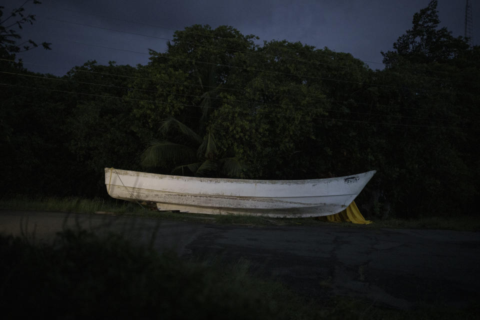 Una embarcación de pesca tradicional mauritana, llamada piragua, a un lado de una carretera en Belle Garden, en la isla caribeña de Tobago, en Trinidad y Tobago, el 18 de enero de 2022. El barco fue encontrado por pescadores locales cuando navegaba a la deriva cerca de la isla el 28 de mayo de 2021, con 14 cadáveres y otros restos óseos en su interior. Una investigación de The Associated Press halló que el cayuco había salido del puerto de Nuadibú, en Mauritania, África, más de cuatro meses antes con 43 migrantes a bordo. (AP Foto/Felipe Dana)