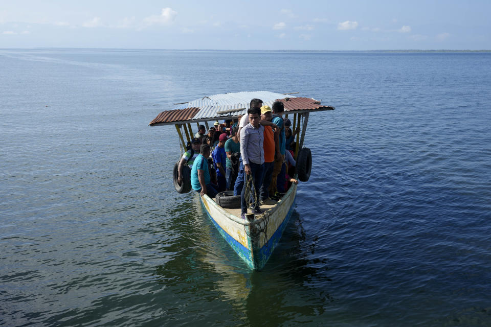 Residents from the nearby village of Pataxte arrive to El Estor, Guatemala, Monday, Oct. 25, 2021, during permitted hours of travel amid a curfew. The Guatemalan government has declared a month-long, dawn-to-dusk curfew and banned pubic gatherings following protests against a nickel mining project. (AP Photo/Moises Castillo)