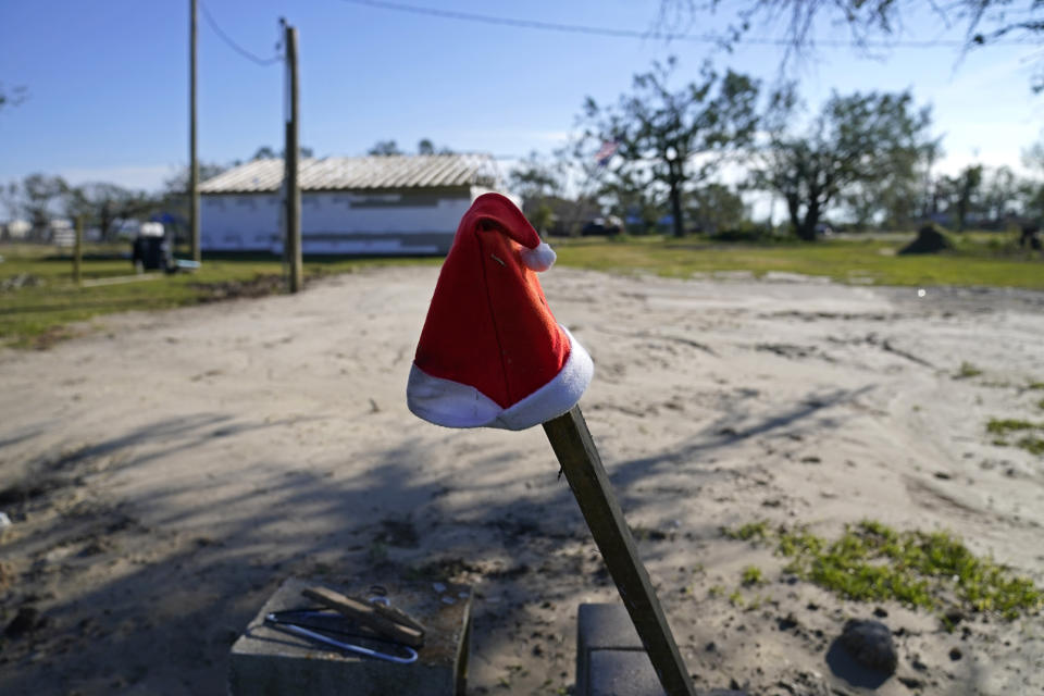 A Santa hat sits on a pole on a lot where Dewana Young's mother's home once stood before Hurricane Laura and Hurricane Delta, in Grand Lake, La., Friday, Dec. 4, 2020. (AP Photo/Gerald Herbert)