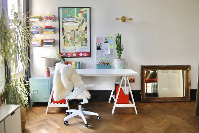 A desk space with a white desk and white officer chair.