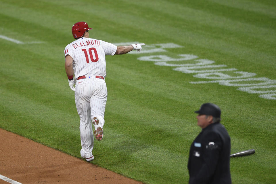 Philadelphia Phillies' J.T. Realmuto points to the dugout after hitting a two-run home run during the first inning of a baseball game, Monday, May 3, 2021, in Philadelphia. (AP Photo/Derik Hamilton)