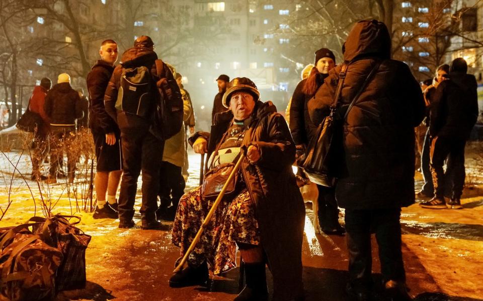 Locals gather outside an apartment building damaged in the attack