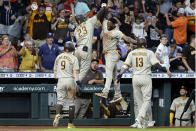 San Diego Padres designated hitter Fernando Tatis Jr. (23) and Jurickson Profar, center right, jump in celebration of Tatis' three-run home run as Jake Cronenworth (9) and Manny Machado (13) look on during the ninth inning of a baseball game against the Houston Astros, Saturday, May 29, 2021, in Houston. (AP Photo/Michael Wyke)