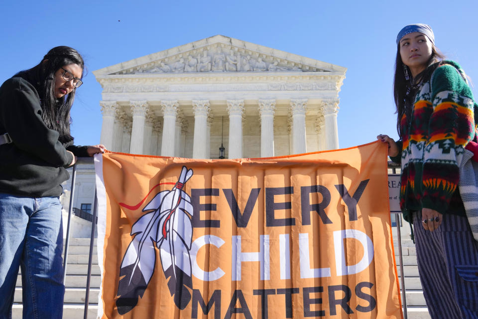 FILE - Demonstrators stand outside of the U.S. Supreme Court, as the court hears arguments over the Indian Child Welfare Act on Nov. 9, 2022, in Washington. The Supreme Court has preserved the system that gives preference to Native American families in foster care and adoption proceedings of Native children. The court left in place the 1978 Indian Child Welfare Act, which was enacted to address concerns that Native children were being separated from their families and, too frequently, placed in non-Native homes. (AP Photo/Mariam Zuhaib, File)