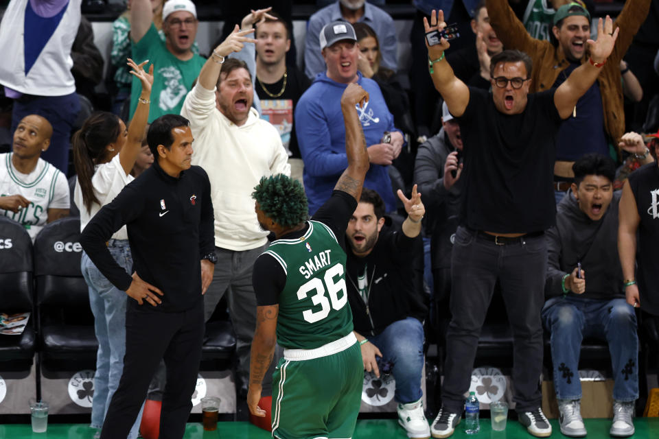 Boston Celtics guard Marcus Smart (36) celebrates along with fans after scoring as Miami Heat head coach Erik Spoelstra, third from left, watches during the second half in Game 5 of the NBA basketball Eastern Conference finals Thursday, May 25, 2023, in Boston. (AP Photo/Michael Dwyer)