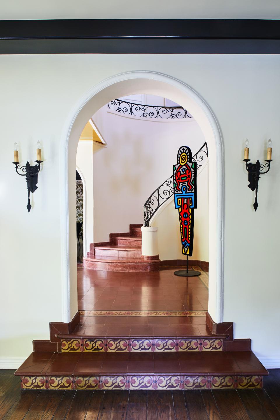 The foyer in musician and producer Mark Ronson's 1930s L.A. home features a grand rotunda with a curved staircase and its original artwork. “I lacquered the banisters black,” says Ronson, who was looking to bring some small personal touches to what was already a successful space. He took a Keith Haring totem, meant to be hung on the wall, and turned it into a sentry of sorts by adding a custom base. “I just knew that I wanted it greeting people as they entered the house,” he adds.