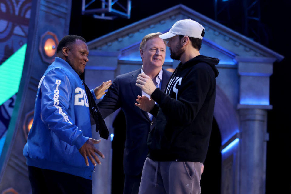 Former player Barry Sanders shakes hands with rapper Marshall 