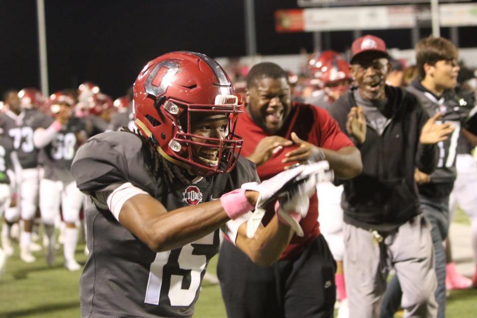 Ouachita players and coaches celebrate a Lion touchdown on the sideline.