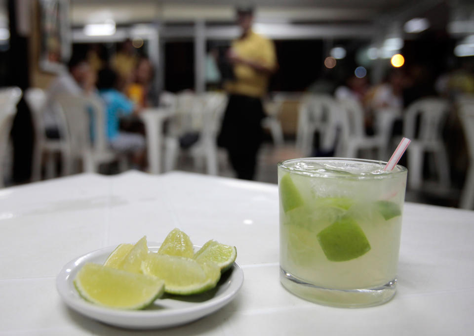 In this April 11, 2013 photo, a glass of "caipirinha" sits on a restaurant table in Brasilia, Brazil, April 11, 2013. The vast majority of cachaca, Brazil's national spirit, is consumed domestically, much of it sipped in Brazil's famed caipirinha cocktails with lime, sugar and crushed ice. (AP Photo/Eraldo Peres)