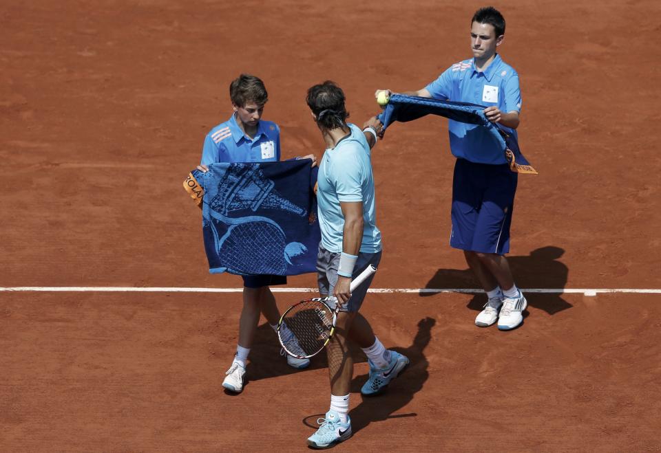 Ball boys give towels to Rafael Nadal at the French Open last year. He's bringing two these days, to try to speed it up. (REUTERS/Vincent Kessler)