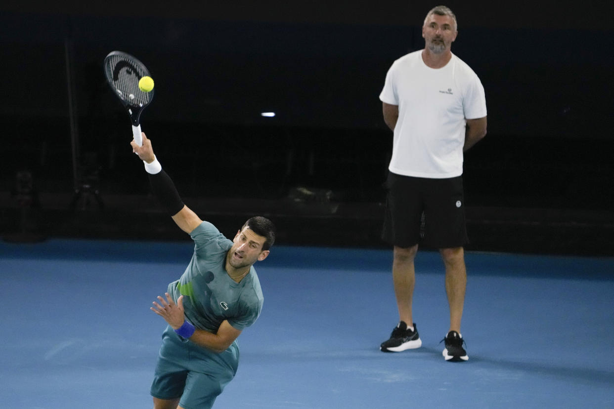FILE - Serbia's Novak Djokovic serves as his coach Goran Ivanisevic watches during a practice session ahead of the Australian Open tennis championships at Melbourne Park, Melbourne, Australia, Saturday, Jan. 13, 2024. Djokovic has split with coach Goran Ivanisevic, ending their association that began in 2018 and included 12 Grand Slam titles for the Serbian tennis player, Djokovic wrote in a post on Instagram published Wednesday, March 27, 2024. (AP Photo/Andy Wong, File)