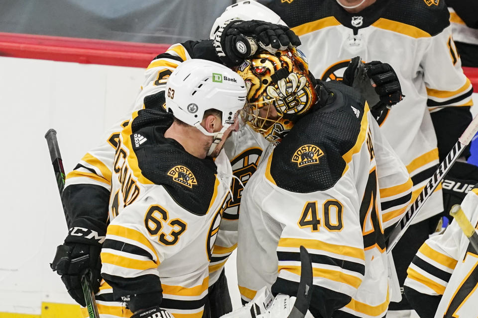 Boston Bruins center Brad Marchand, left, celebrates with goaltender Tuukka Rask (40) after scoring the winning goal in overtime of Game 2 of an NHL hockey Stanley Cup first-round playoff series against the Washington Capitals, Monday, May 17, 2021, in Washington. The Bruins won 4-3. (AP Photo/Alex Brandon)