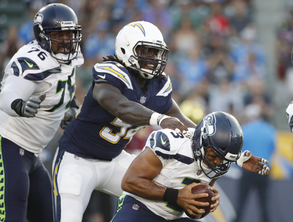 Seattle Seahawks quarterback Russell Wilson, right, is sacked by Los Angeles Chargers defensive end Melvin Ingram during the first half of an NFL preseason football game Saturday, Aug. 18, 2018, in Carson, Calif. (AP Photo/Jae C. Hong)