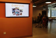 A video display shows photos and the logo for Mary's Place, a family homeless shelter located inside an Amazon corporate building on the tech giant's Seattle campus, Wednesday, June 17, 2020. The shelter marks a major civic contribution bestowed by Amazon to the hometown it has rapidly transformed. (AP Photo/Ted S. Warren)