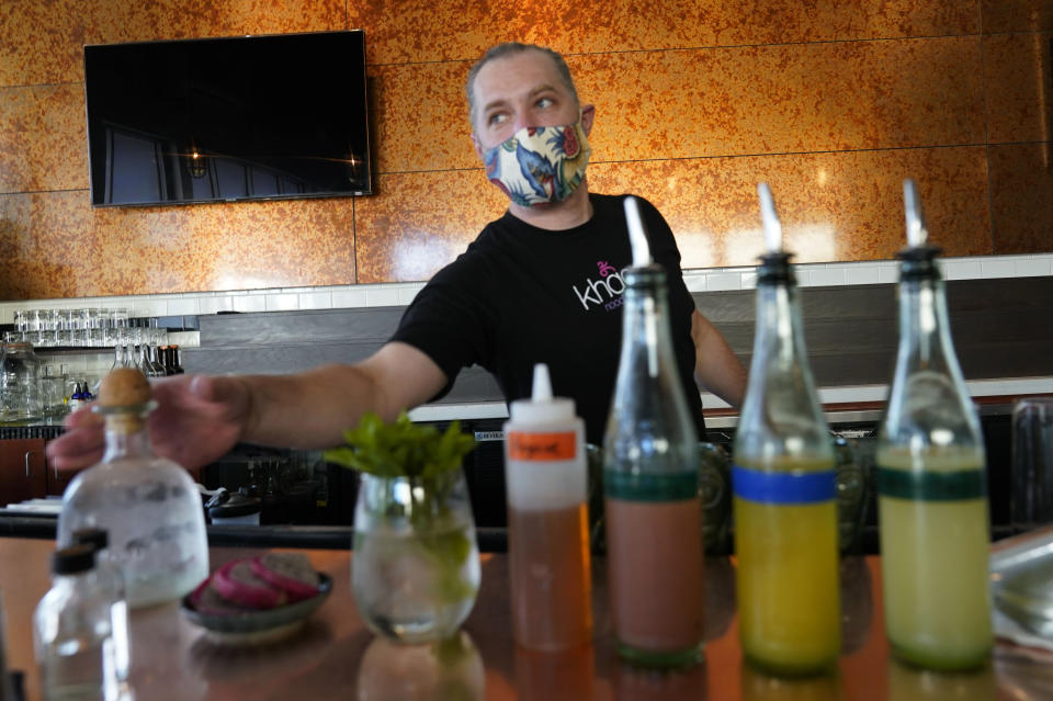 Devin McCullough, general manager of the The People's Last Stand craft cocktail bar, prepares for a mixology class in Dallas, Thursday, Aug. 13, 2020. Some states and cities in the U.S. are allowing cocktails to-go due to the pandemic and this specialty bar offers takeout mixers for customers to make drinks at home. (AP Photo/LM Otero)