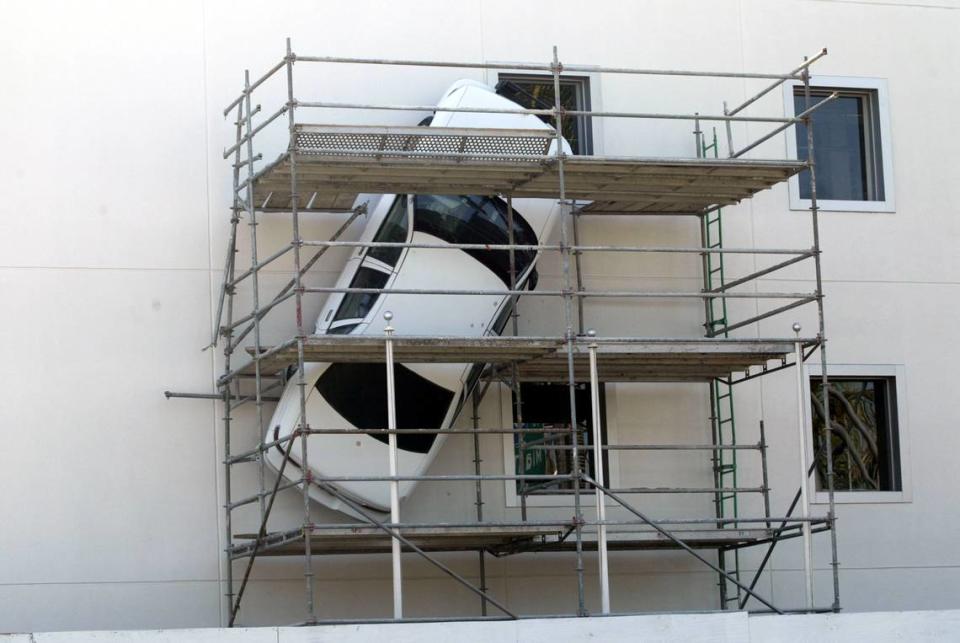 In 2004, a police car hanging from the side of the old Police Museum on Biscayne Boulevard is prepared to be transformed into a rescue vehicle for a new medical complex in the building.