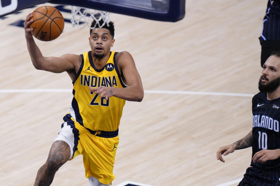 Indiana Pacers guard Jeremy Lamb (26) shoots a layup in front of Orlando Magic guard Evan Fournier (10) during the second half of an NBA basketball game in Indianapolis, Friday, Jan. 22, 2021. (AP Photo/AJ Mast)