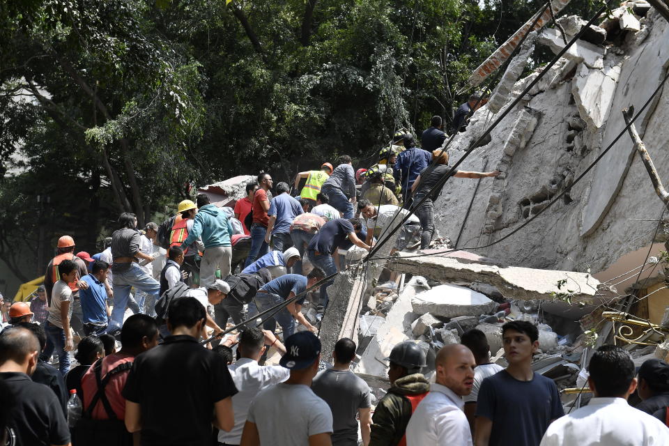 People search through debris.&nbsp;