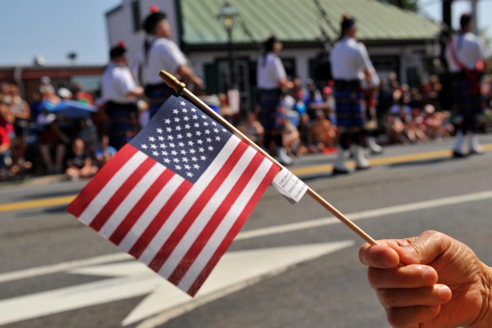 Parade spectators wave American flags during a Virginia Independence Day parade.