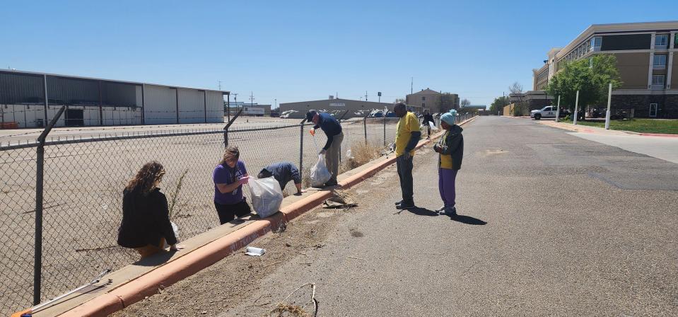 Volunteers with Keep Amarillo Clean clean up area outside the closed United Artists movie theatre Monday near Amarillo Boulevard in West Amarillo.