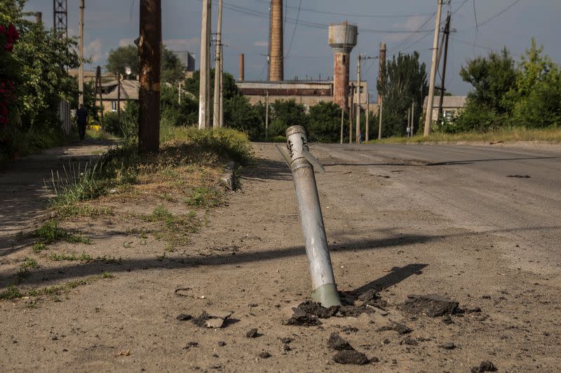 Un proyectil sin explotar de un sistema de lanzamiento de cohetes múltiples se ve atrapado entre una calle, mientras continúa el ataque de Rusia contra Ucrania, en Lysychansk, región de Lugansk, Ucrania