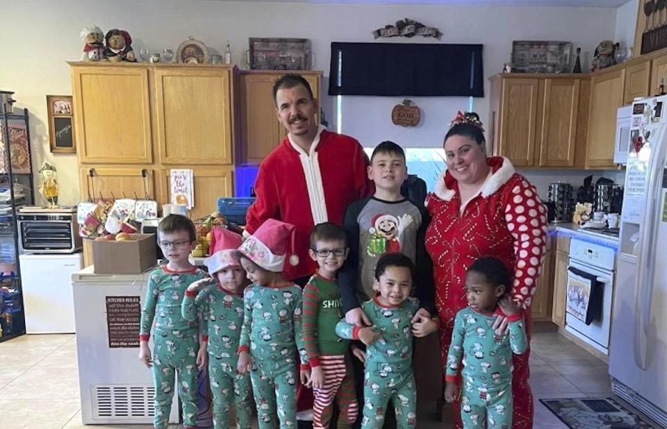 In this photo provided by Karen Lopez, she and her husband, Jerry Lopez, are seen with their seven children in December 2023. Jerry Lopez, 39, was killed in Las Vegas two days after Christmas while on his way to work in what Las Vegas police say was the final carjacking in a crime spree. (Karen Lopez via AP)