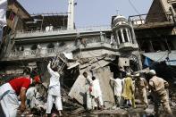 Security officials, rescue workers and residents gather at the site of a bomb attack in Peshawar September 29, 2013. Twin blasts in the northwestern Pakistan city of Peshawar killed 33 people and wounded 70 on Sunday, a week after two bombings at a church in the frontier city killed scores, police and hospital authorities said. REUTERS/Khuram Parvez (PAKISTAN - Tags: POLITICS CIVIL UNREST CRIME LAW TPX IMAGES OF THE DAY)