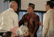 Abdullah Macapaar, center, who uses the nom de guerre Commander Bravo, talks with Defense Secretary Delfin Lorenzana, left, and Presidential Adviser on the Peace Process Carlito Galvez following oath-taking ceremony for the creation of the Bangsamoro Transition Authority or BTA at the Presidential Palace in Manila, Philippines Friday, Feb. 22, 2019. The Muslim rebels will serve as administrators of a new Muslim autonomous region in a delicate milestone to settle one of Asia's longest-raging rebellions. Several commanders, including Commander Bravo, long wanted for deadly attacks were given safety passes to be able to travel to Manila and join the ceremony.(AP Photo/Bullit Marquez)