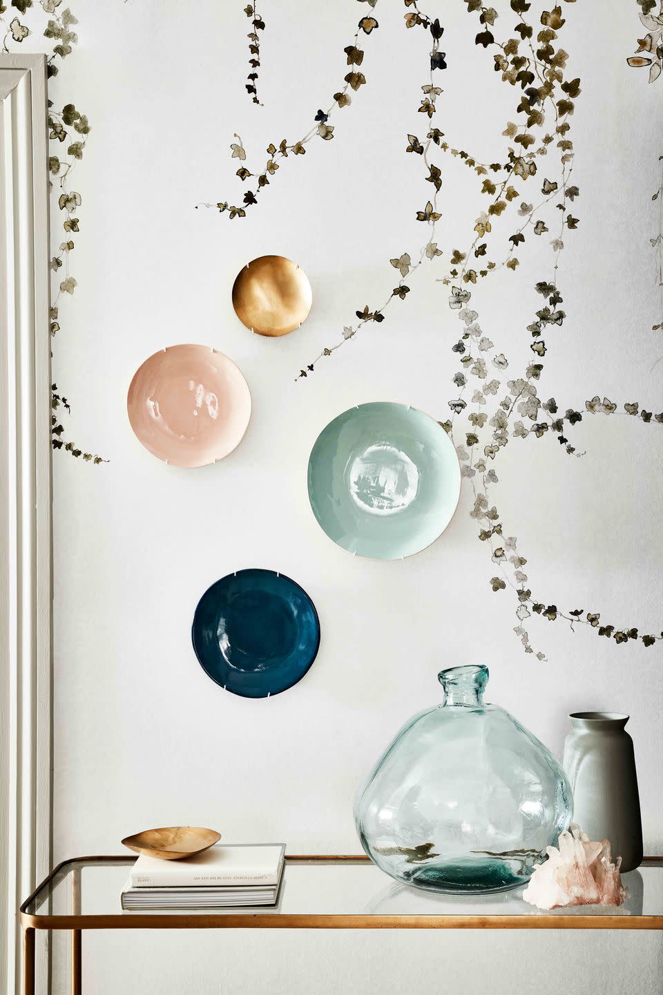 <p>A group of burnished brass and glazed ceramic plates in a variety of colours makes for an eye-catching display.</p>
