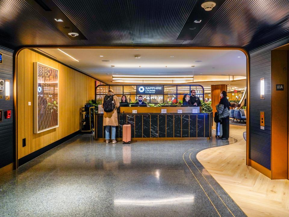 Dark and good walls with gold finishings in front of the lounge's welcome desk