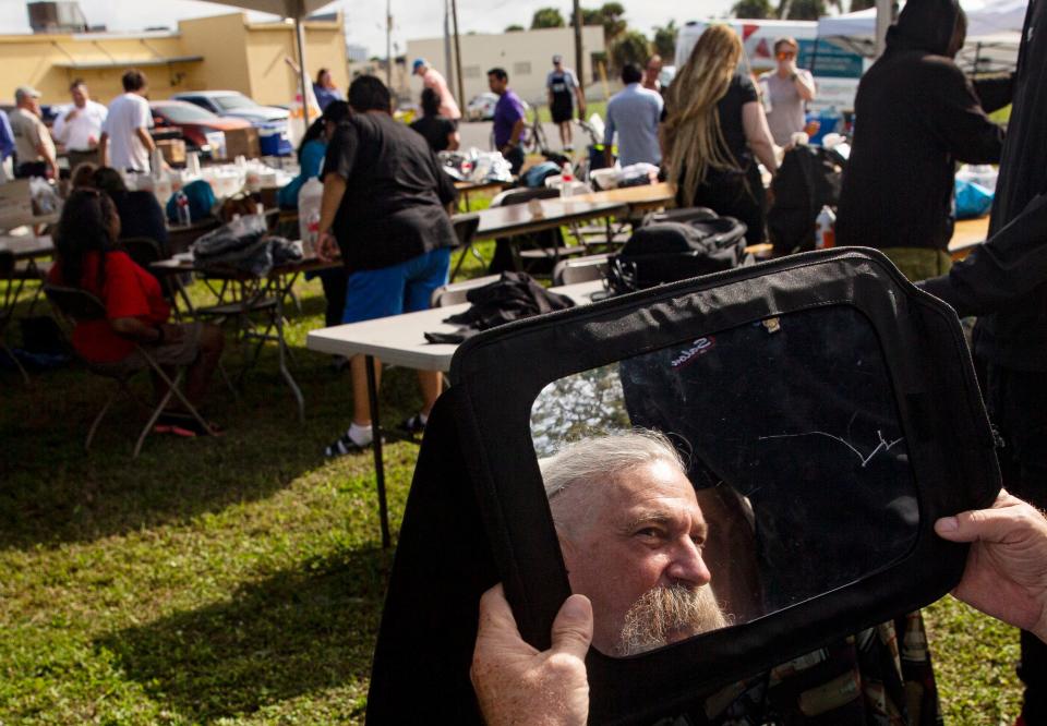 Mark Cabral checks out his hair after having it trimmed at Collier County Hunger and Homeless CoalitionÕs annual "point in time" homeless count at Gulf Gate Plaza in Naples on Friday, Jan. 26, 2024. Cabral has been homeless in Naples eight years, he said. Vendors were set up at the event to help the homeless which included, food, hygiene kits, clothes and other help.