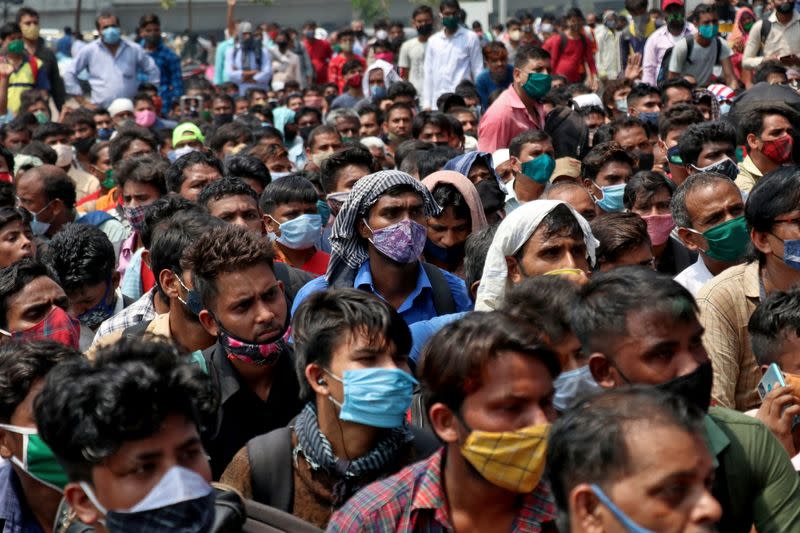 People wearing protective face masks wait to enter the Lokmanya Tilak Terminus railway station, amid the spread of the coronavirus disease (COVID-19) in Mumbai