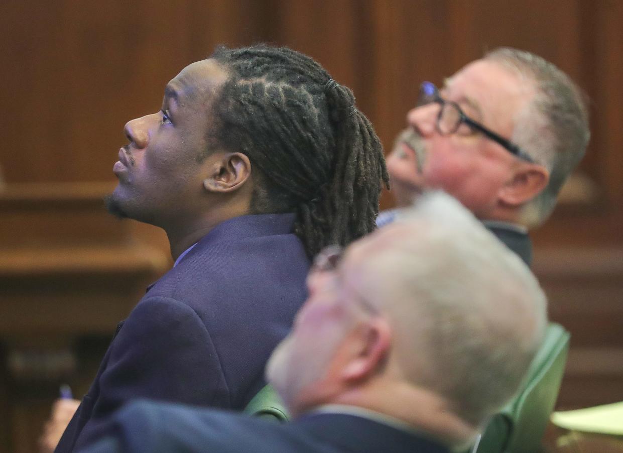 Leon Newsome, left, sits with his defense lawyers John Greven, top, and Nathan Ray as prosecutors present evidence on a video monitor  Wednesday in Summit County Common Pleas Court. Newsome is accused of starting a fire at a Carpenter Street home that killed a couple in 2022.