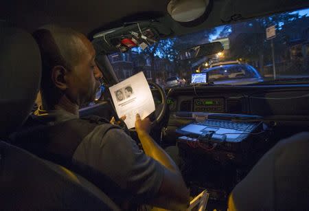 A Cook County Sheriff police officer looks over paperwork for an outstanding arrest warrants in the Austin neighborhood in Chicago, Illinois, United States, September 9, 2015. REUTERS/Jim Young