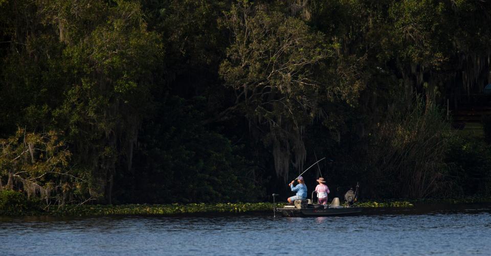 People fish in the Caloosahatchee River near LaBelle on Wednesday, Oct. 11, 2023.