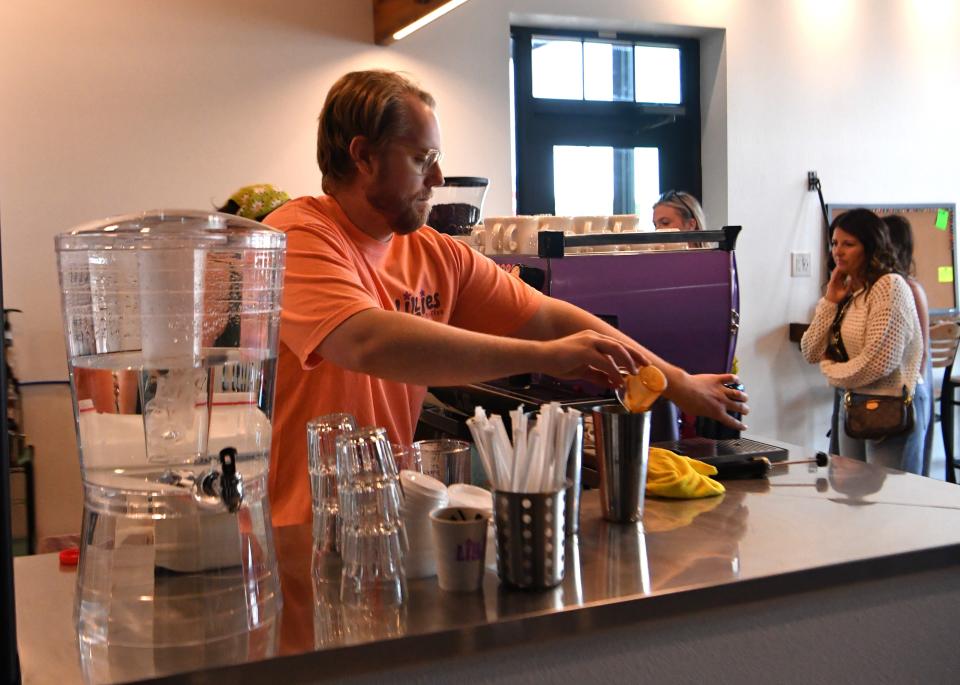 Patrick Riordan, co-owner of Lillies Coffee with wife Alexandra Riordan, helps serve customers during the grand opening Saturday in Henrietta.