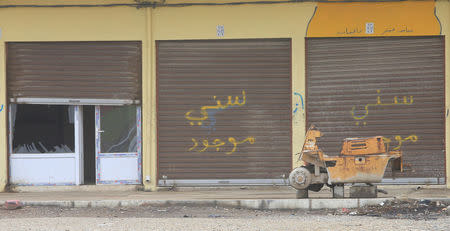 The slogan "Sunni maujud", or a Sunni is inside, is written on a shop in Mosul, Iraq, December 1, 2016. REUTERS/Stringer