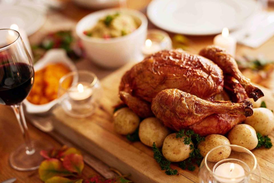 <p>Yuri Arcurs Productions / Getty Images</p> A Thanksgiving spread accompanied by red wine