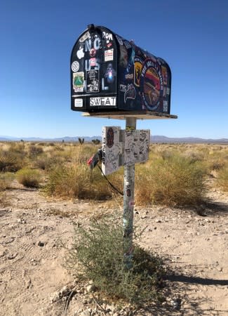 The black mailbox showing various-themed stickers stands outside Area 51 in Rachel, Nevada