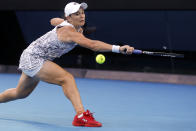 Ash Barty of Australia makes a backhand return to Amanda Anisimova of the U.S. during their fourth round match at the Australian Open tennis championships in Melbourne, Australia, Sunday, Jan. 23, 2022. (AP Photo/Hamish Blair)