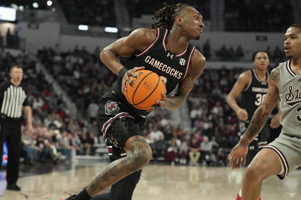 South Carolina guard Zachary Davis (12) starts to approach the basket while defended by Mississippi State guard Shakeel Moore (3) during the first half of an NCAA college basketball game, Saturday, March 9, 2024, in Starkville, Miss. South Carolina won 93-89 in overtime. (AP Photo/Rogelio V. Solis)